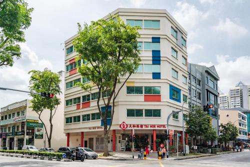 un grand bâtiment blanc dans une rue de la ville dans l'établissement Tai Hoe Hotel, à Singapour