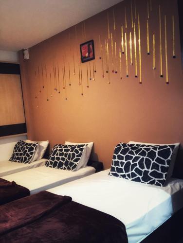 two beds in a room with chandeliers on the wall at Tai Hoe Hotel in Singapore