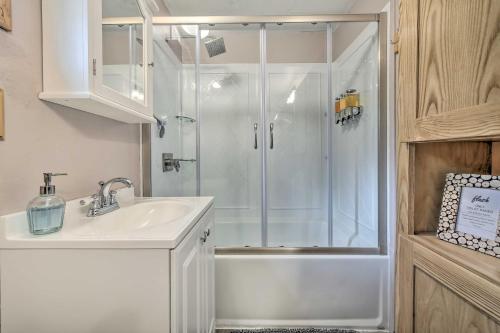 baño blanco con ducha y lavamanos en Wandering Elk Cabin Retreat with Golf Access! en Packwood