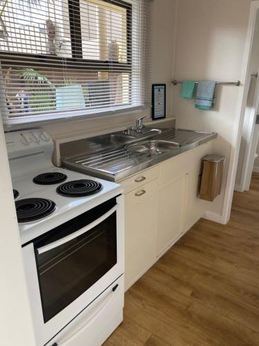 a kitchen with a white stove and a sink at Wayfarer Motel in Kaitaia