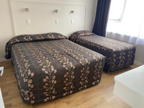 A bed or beds in a room at Wayfarer Motel