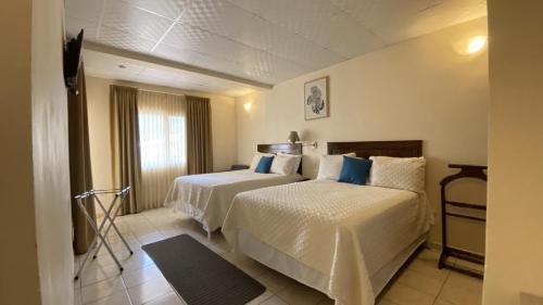 una camera d'albergo con due letti e una finestra di Real Guanacaste a San Pedro Sula