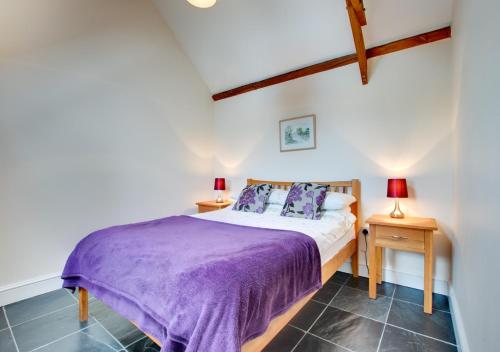 BegellyにあるLove Cottage - Begellyのベッドルーム1室(紫のシーツとランプ2つ付)