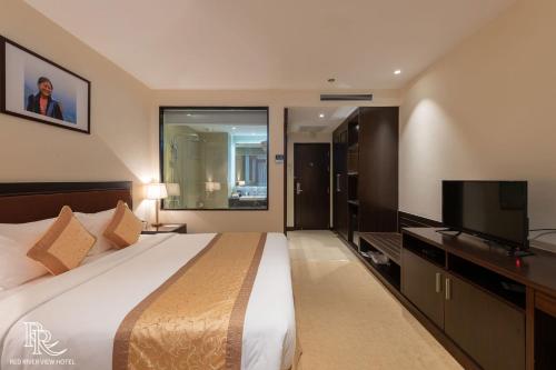 a bedroom with a large bed and a flat screen tv at Red River View Hotel in Lao Cai