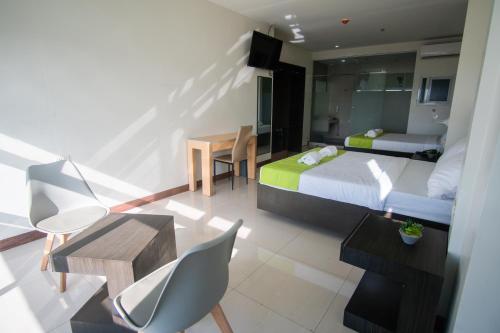 a hotel room with a bed and a table and chairs at Benrose Hotel in Cagayan de Oro