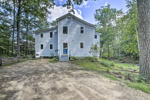 an old white house in the middle of the forest at Lakefront Family Retreat Skiing and Mountain Biking in Greenwood