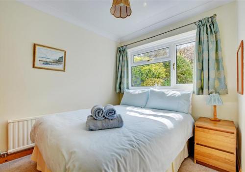 a bedroom with a bed with two towels on it at Hallstatt in Saundersfoot