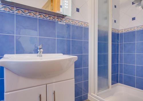 uma casa de banho com um lavatório e um chuveiro em Hallstatt em Saundersfoot