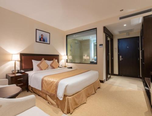 a hotel room with a large bed and a television at Red River View Hotel in Lao Cai
