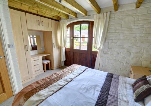 a bedroom with a bed and a stone wall at Holly Cottage in Haverfordwest