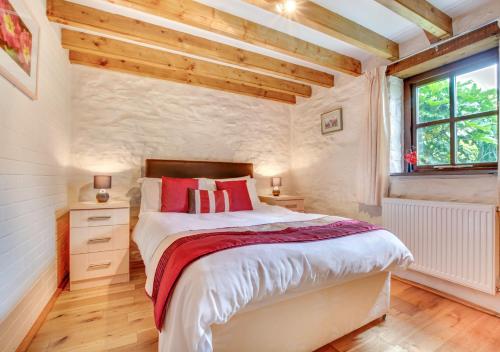 a bedroom with a large bed and a window at Primrose Cottage in Haverfordwest