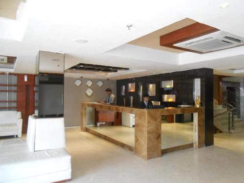 two men standing at a bar in a room at Hotel O2 Oxygen in Kolkata