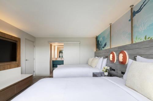 a bedroom with two beds and a flat screen tv at Crowne Plaza Resort Guam in Tumon