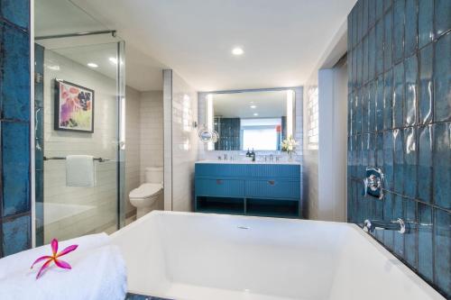 a bathroom with a tub and a sink and a toilet at Crowne Plaza Resort Guam in Tumon