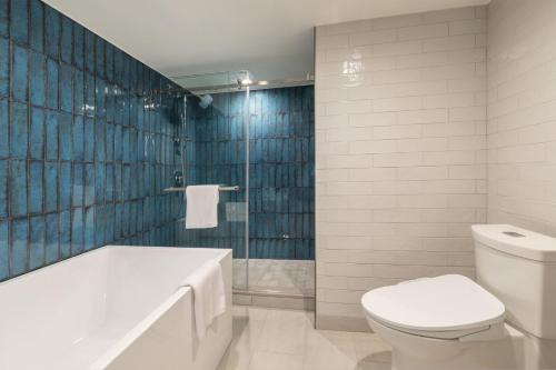 a bathroom with a tub and a toilet and a sink at Crowne Plaza Resort Guam in Tumon
