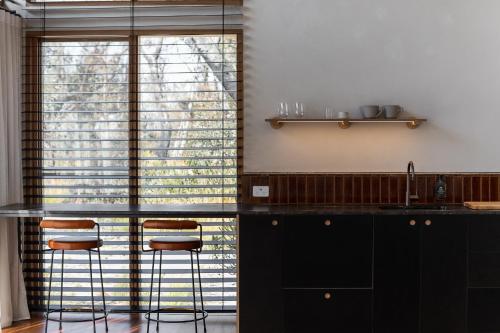 a kitchen with black cabinets and a counter with stools at Chalets at Blackheath in Blackheath