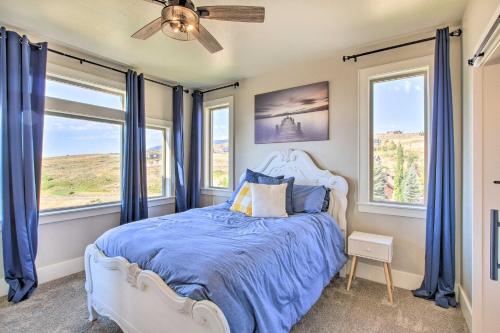 a bedroom with a bed with blue sheets and windows at Fish Haven Hideaway with Private Lake Access! in Fish Haven