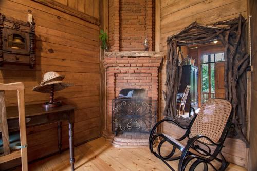 a room with a fireplace and a chair and a table at Menabde Winery in Ozurgetʼi