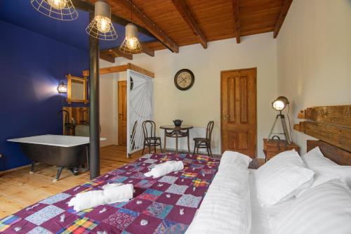 a bedroom with a bed and a tub and a table at Menabde Winery in Ozurgetʼi