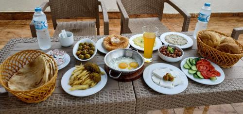 een tafel met borden met eten en drinken erop bij Grand Pyramids Inn in Caïro