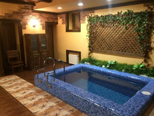 a swimming pool in a house with a blue tile floor at Pan Otaman in Pisarevka