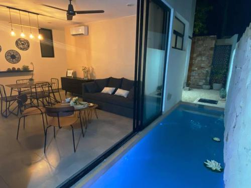 a view of a living room with a swimming pool at Villa Maia, Lovely 1 bedroom apartment with pool in Mérida