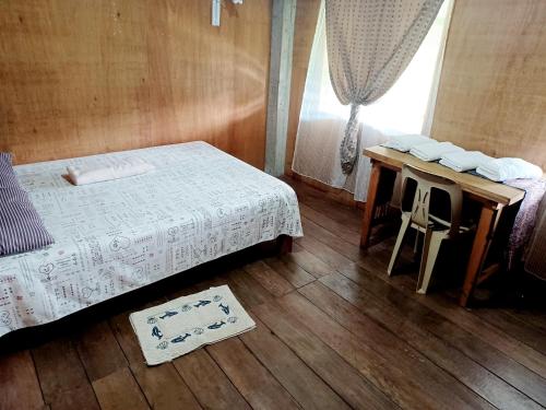 een slaapkamer met een bed, een tafel en een raam bij Batad Countryside in Banaue