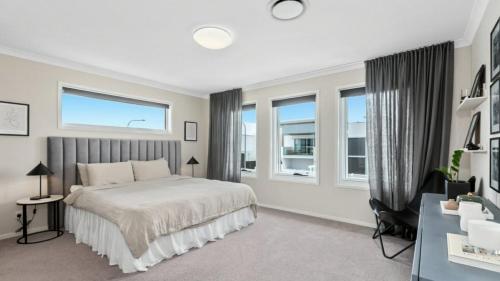 une chambre avec un lit et deux fenêtres dans l'établissement Putt Putt - Pool Slide - 100m to Beach - Ultimate Family Entertainer, à Kingscliff