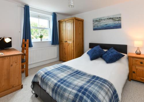 a bedroom with a bed and a desk and a television at Tyddyn Talgoch Isaf in Abersoch