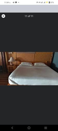 a bedroom with a bed with a wooden head board at Lazy Hut in Ko Phayam