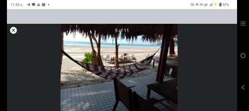 a hammock on a beach with a view of the ocean at Lazy Hut in Ko Phayam