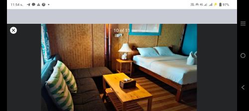 a hotel room with a bed and a couch at Lazy Hut in Ko Phayam