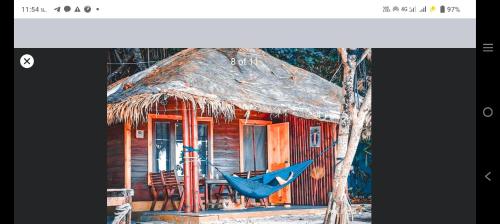 a blue hammock in front of a house at Lazy Hut in Ko Phayam