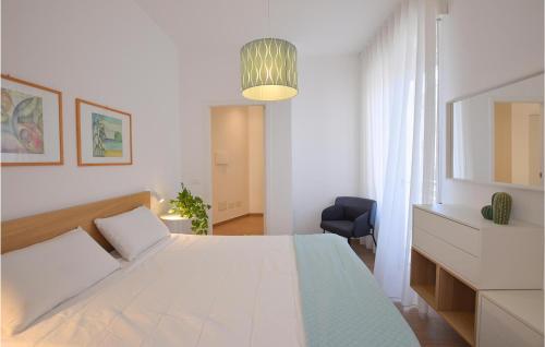 een witte slaapkamer met een bed en een blauwe stoel bij 1 Bedroom Nice Apartment In Pozzallo in Pozzallo