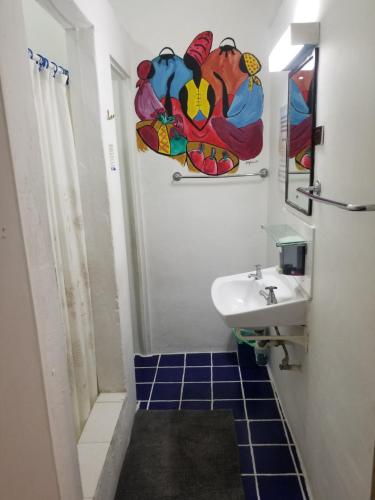 a bathroom with a sink and a toilet and a mirror at Rio Guesthouses in Christ Church