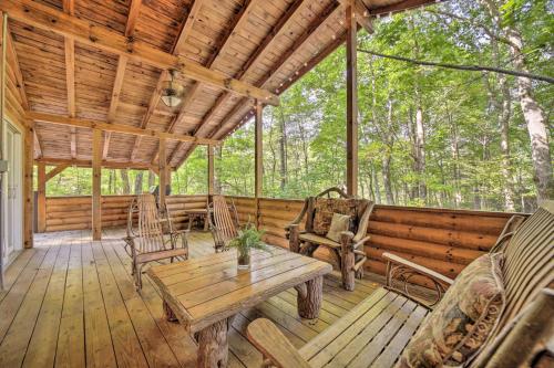 a wooden porch with a wooden table and chairs at Fire Pit and Grill Cozy Cabin in Lake Toxaway! in Lake Toxaway