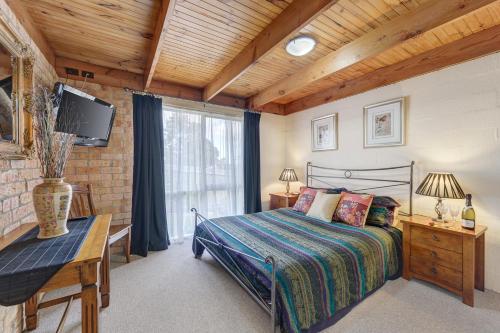 ein Schlafzimmer mit einem Bett und einem großen Fenster in der Unterkunft Bungunyah Apartments in Croydon