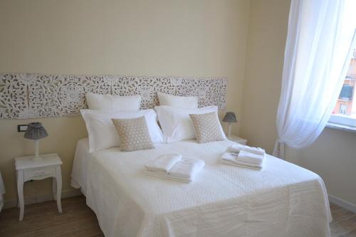 a bedroom with a white bed with towels on it at Affittacamere Casa Dane' in La Spezia