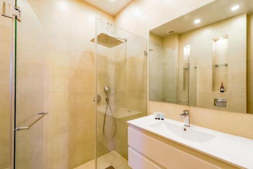 a bathroom with a sink and a glass shower at Duplex In Flea Market by Holiday-rentals in Tel Aviv