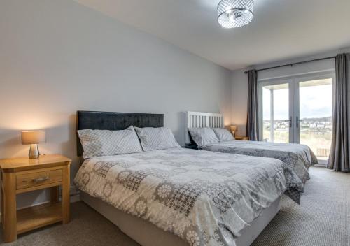 a bedroom with two beds and a window at The Retreat in Saundersfoot