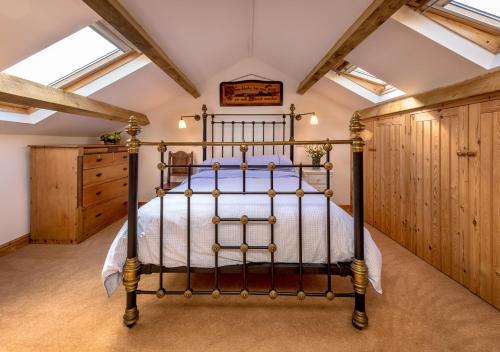 ein Schlafzimmer mit einem Bett in einem Zimmer mit Holzschränken in der Unterkunft The Barn in Llannor