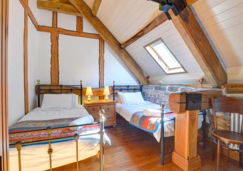 Threshing Barn في Llansawel: غرفة نوم علوية بسريرين وطاولة