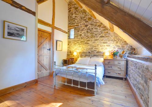 a bedroom with a bed and a stone wall at Pipistrelle in Llansawel