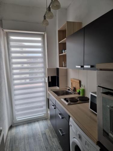 una cucina con finestra con persiane bianche di B&R Apartment in Humboldtstraße a Norimberga