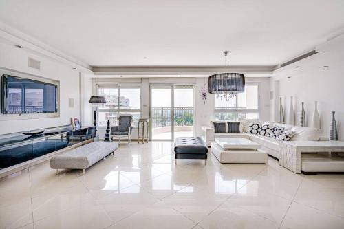 a large living room with white furniture and windows at Duplex Penthouse 3BR Asirey Tsyon By Holiday-rentals in Tel Aviv