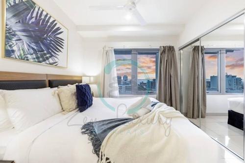 sypialnia z białym łóżkiem i oknami w obiekcie ZEN OCEAN BLISS - Cozy 2-BR/2-BA Sea View Retreat w mieście Darwin