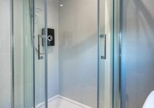 a shower with a glass door in a bathroom at Pelydryn in Abersoch
