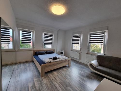 ein Schlafzimmer mit einem Bett, einem Sofa und Fenstern in der Unterkunft B&R Apartment in Humboldtstraße in Nürnberg