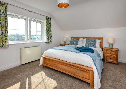 um quarto com uma cama grande e uma janela em Pentraeth Cottage em Abersoch