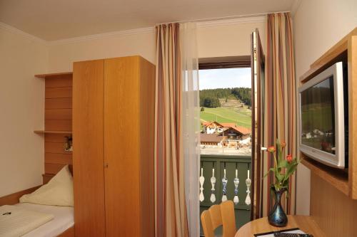 a room with a bed and a window and a table at Gasthof Reiner in Sankt Englmar